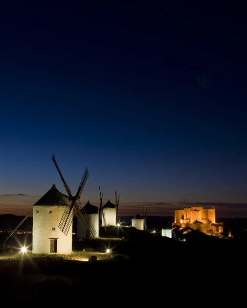 风车与城堡在夜、 孔苏埃格拉、 卡斯蒂利亚拉曼查、 sp — 图库照片