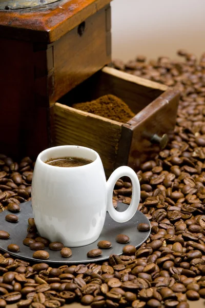 Detalhe do moinho de café com grãos de café e xícara de café — Fotografia de Stock