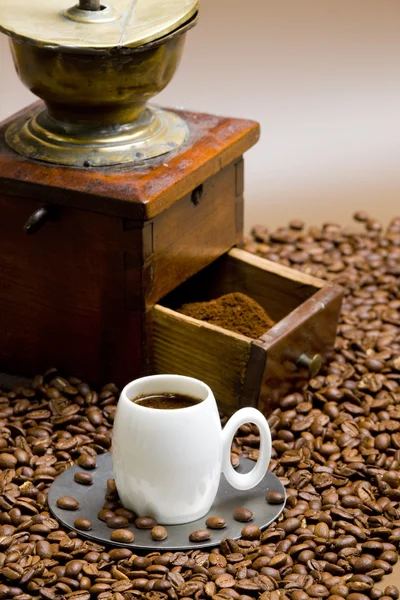 Molino de café con granos de café y taza de café —  Fotos de Stock