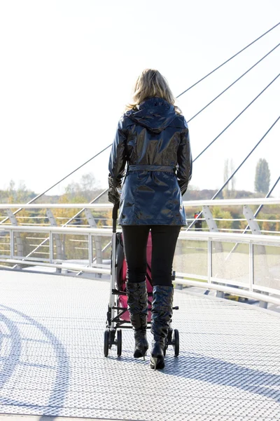 Kvinna med barnvagn på promenad — Stockfoto