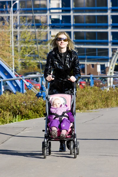 Kvinna med barn sitter i vagnen på promenad — Stockfoto