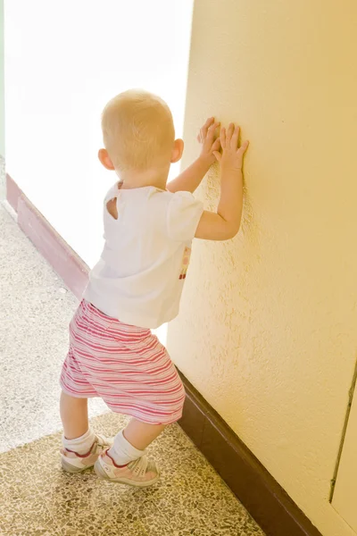Toddler standing at wall — Stock Photo, Image
