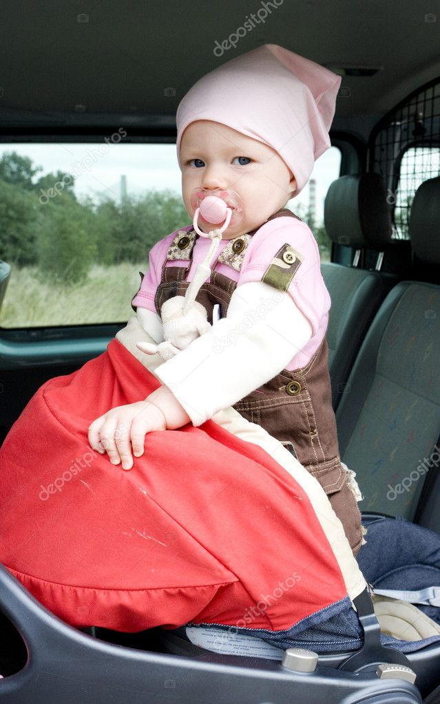 Little girl standing in car seat