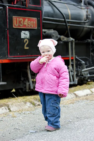 Litte flicka står vid ånglok, ciernohronska järnväg, — Stockfoto
