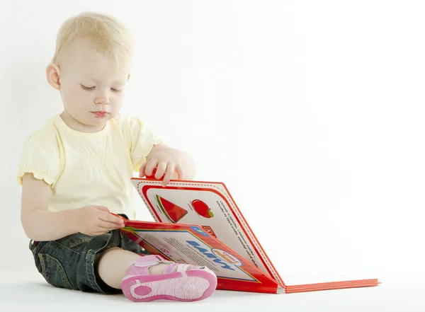 Sitting toddler with a book — Stock Photo, Image