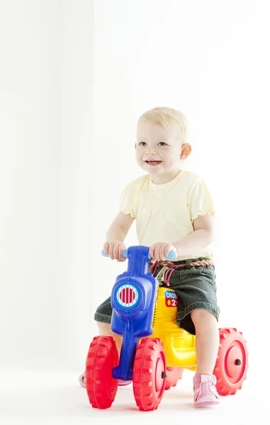 Маленькая девочка на игрушечном мотоцикле — стоковое фото