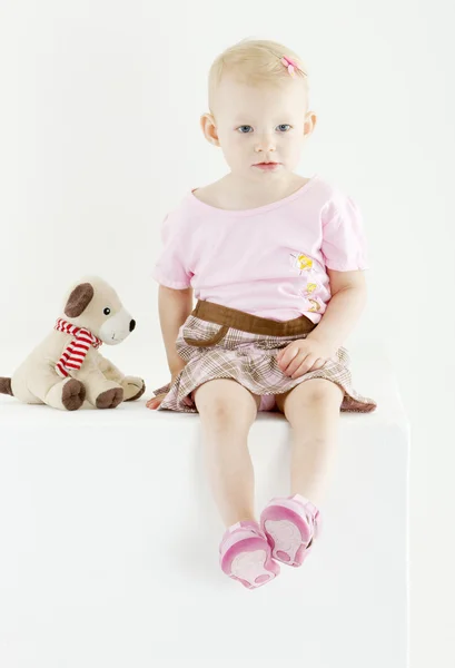 Сидящий ребенок с игрушкой — стоковое фото