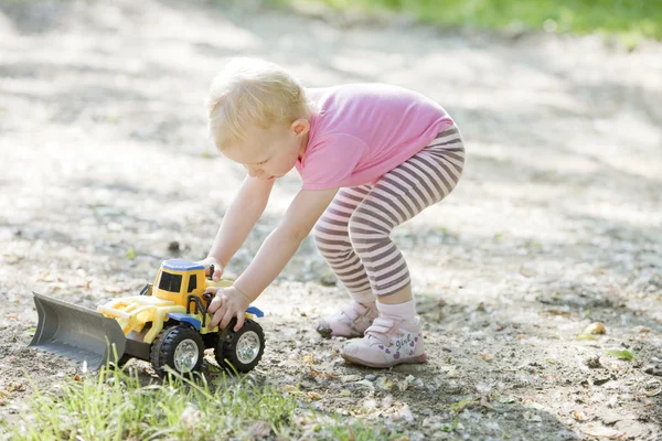 Little girl playing with little excavator — Stock Photo, Image