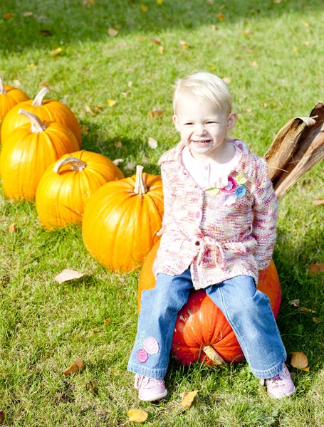Little girl with pumpkins — Stock Photo, Image