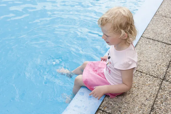 Niña sentada junto a la piscina — Foto de Stock