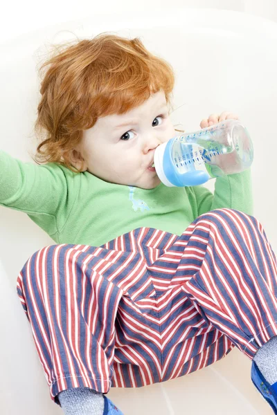 Niño sentado con una botella de agua — Foto de Stock