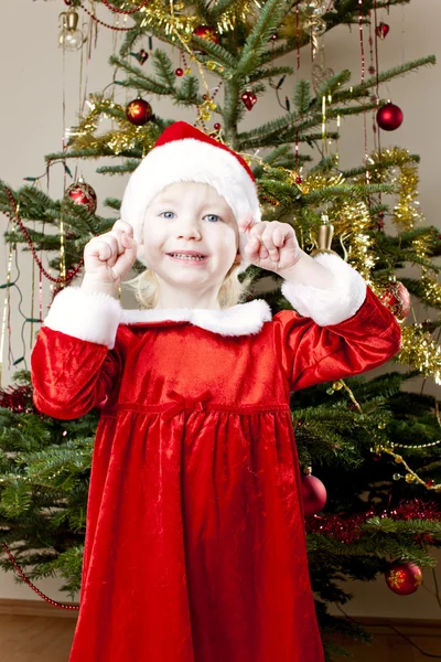 Kleines Mädchen als Weihnachtsmann am Weihnachtsbaum — Stockfoto