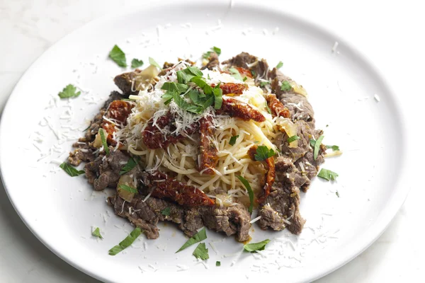 Spagetti sığır eti ve kurutulmuş domates ile — Stok fotoğraf