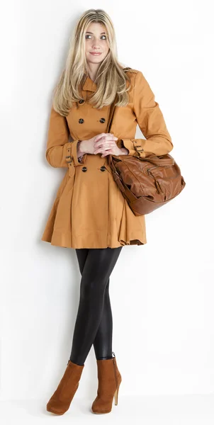Standing woman wearing coat and fashionable brown shoes with a h — Stock Photo, Image