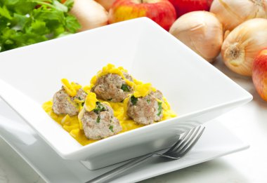 Minced meat and herbs balls in apple and curry sauce clipart