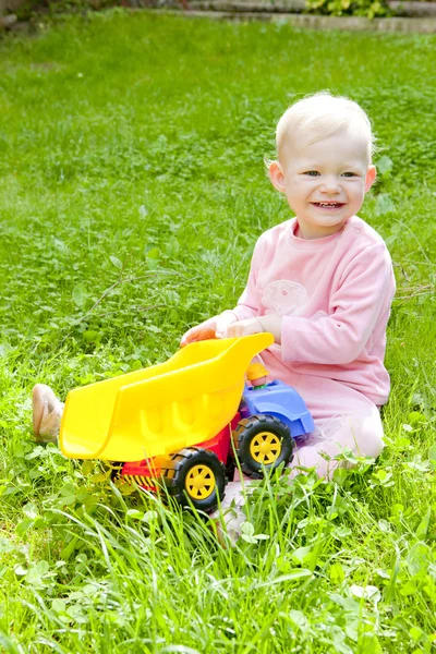 Malá dívka si hraje s malým autem — Stock fotografie