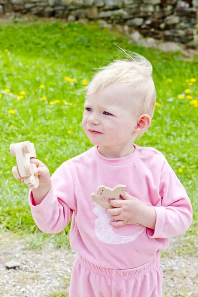 Маленькая девочка играет с деревянными игрушками — стоковое фото