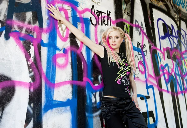 stock image Portrait of young woman standing at graffitti wall