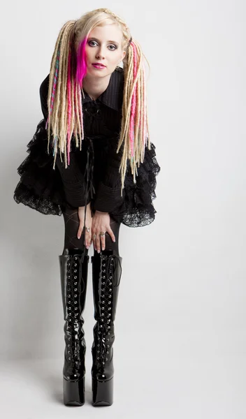 Young woman with dreadlocks wearing extravagant clothes and boot — Stock Photo, Image