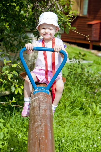 Little girl sitting on swing — Stock Photo, Image