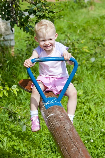 Little girl sitting on swing — Stock Photo, Image