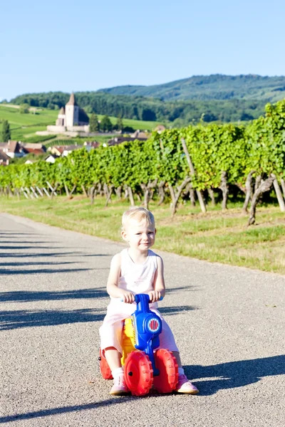 Holčička na hračky motocyklu, hunawihr, Alsasko, Francie — Stock fotografie