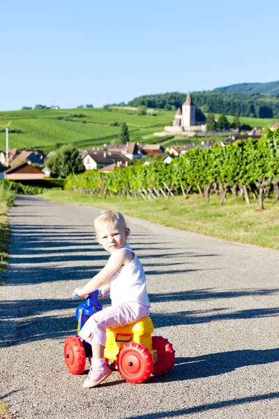 Маленькая девочка на игрушечном мотоцикле, Хунавир, Эльзас, Франция — стоковое фото