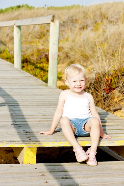 Little girl sitting on footbridge — Stock Photo, Image