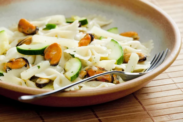 Pasta farfalle with mussels and zucchini — Stock Photo, Image