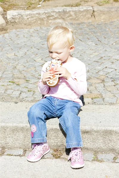 Klein meisje eten peperkoek — Stockfoto