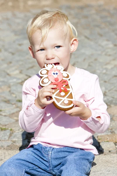 Portrait of little girl eating gingerbread — Stock Photo, Image