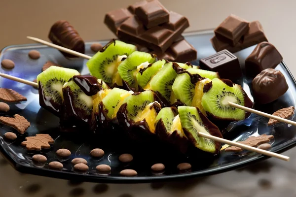 Obstspieße und Schokoladenbonbons — Stockfoto