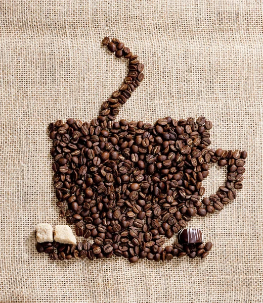 Чашка кофе из кофейных зерен с сахаром и шоколадом — стоковое фото
