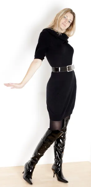 Mulher de pé vestindo vestido preto e botas na moda — Fotografia de Stock