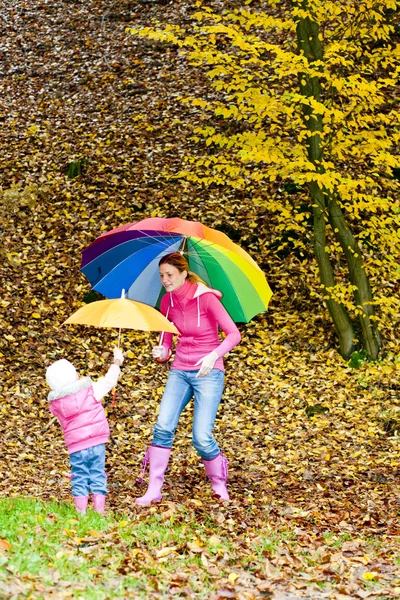 Madre e figlia con ombrelloni nella natura autunnale — Foto Stock