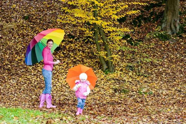 Mãe e sua filha com guarda-chuvas na natureza outonal — Fotografia de Stock