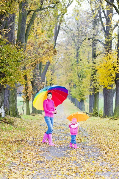 母と娘秋の路地で傘を持つ — ストック写真