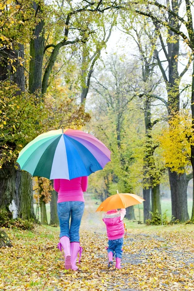 Anne ve kızı ile sonbahar sokakta şemsiye — Stok fotoğraf