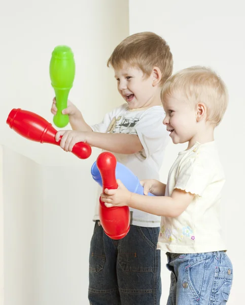 Standing children playing with skittles — Stock Photo, Image