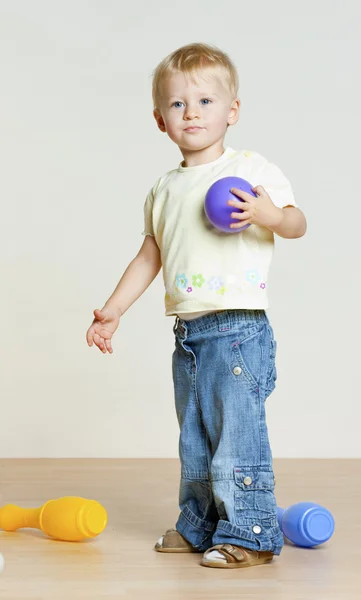 Standing toddler girl playing with skittles — Stock Photo, Image