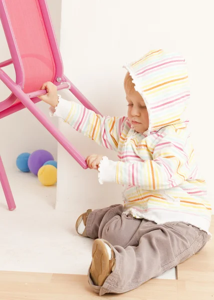 Μικρό παιδί με μια καρέκλα — Φωτογραφία Αρχείου