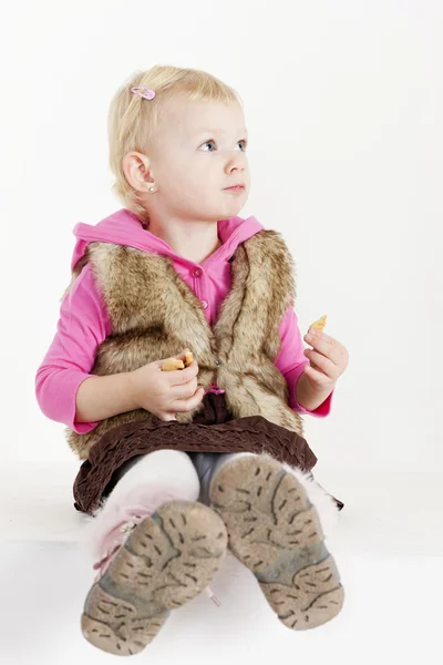 Sedící holčička drží soubory cookie — Stock fotografie