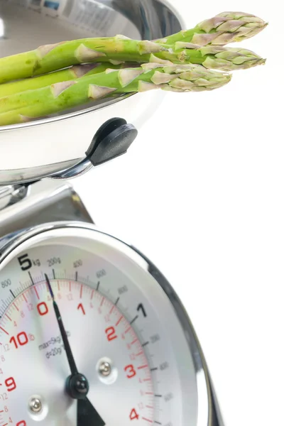 Green asparagus on kitchen scales — Stock Photo, Image