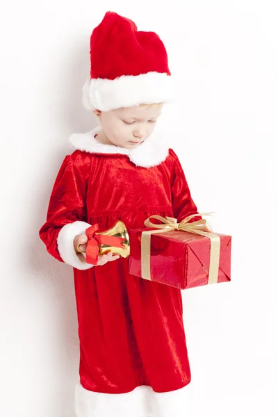 Petite fille comme Père Noël avec une cloche et un cadeau de Noël — Photo