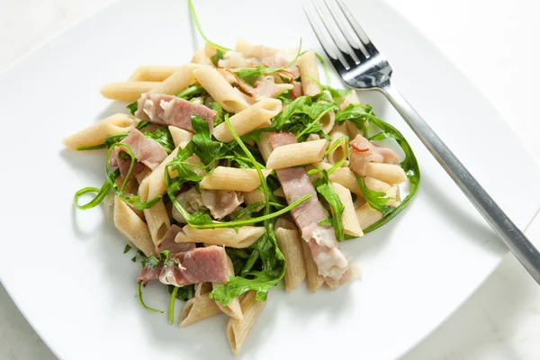 stock image Penne pasta with Parma ham and ruccola