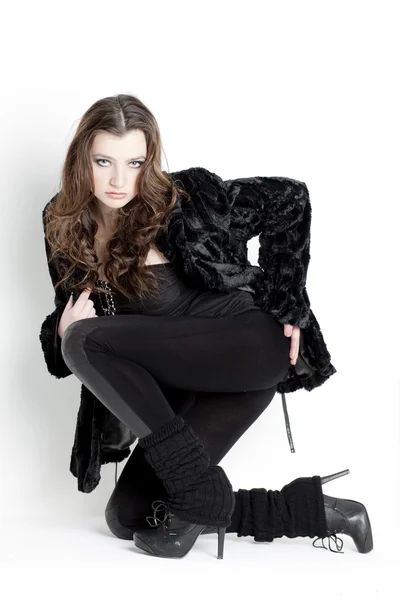 Knielende jonge vrouw dragen zwarte kleding — Stockfoto
