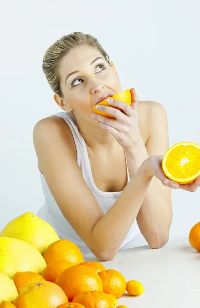 Портрет молодой женщины, которая ест апельсин — стоковое фото