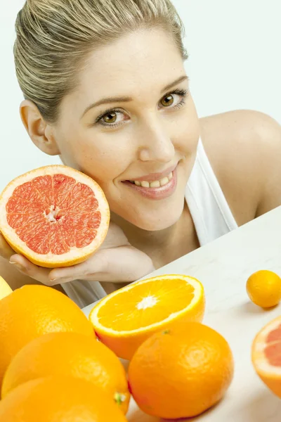 Portret van een jonge vrouw met grapefruit — Stockfoto