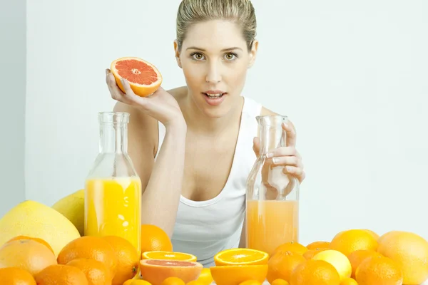 Narenciye ve portakal suyu ile genç kadının portresi — Stockfoto