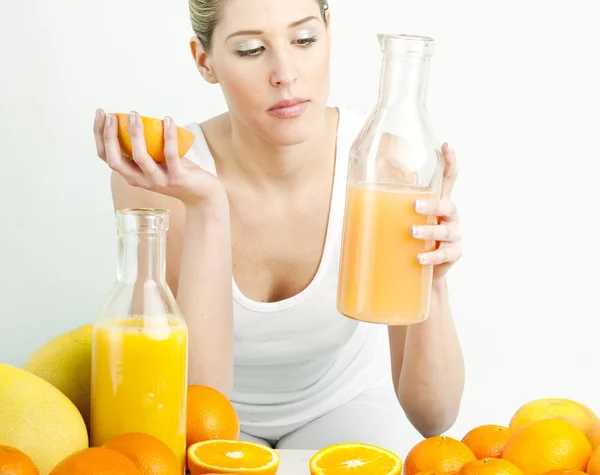 Retrato de mujer joven con cítricos y zumo de naranja — Foto de Stock
